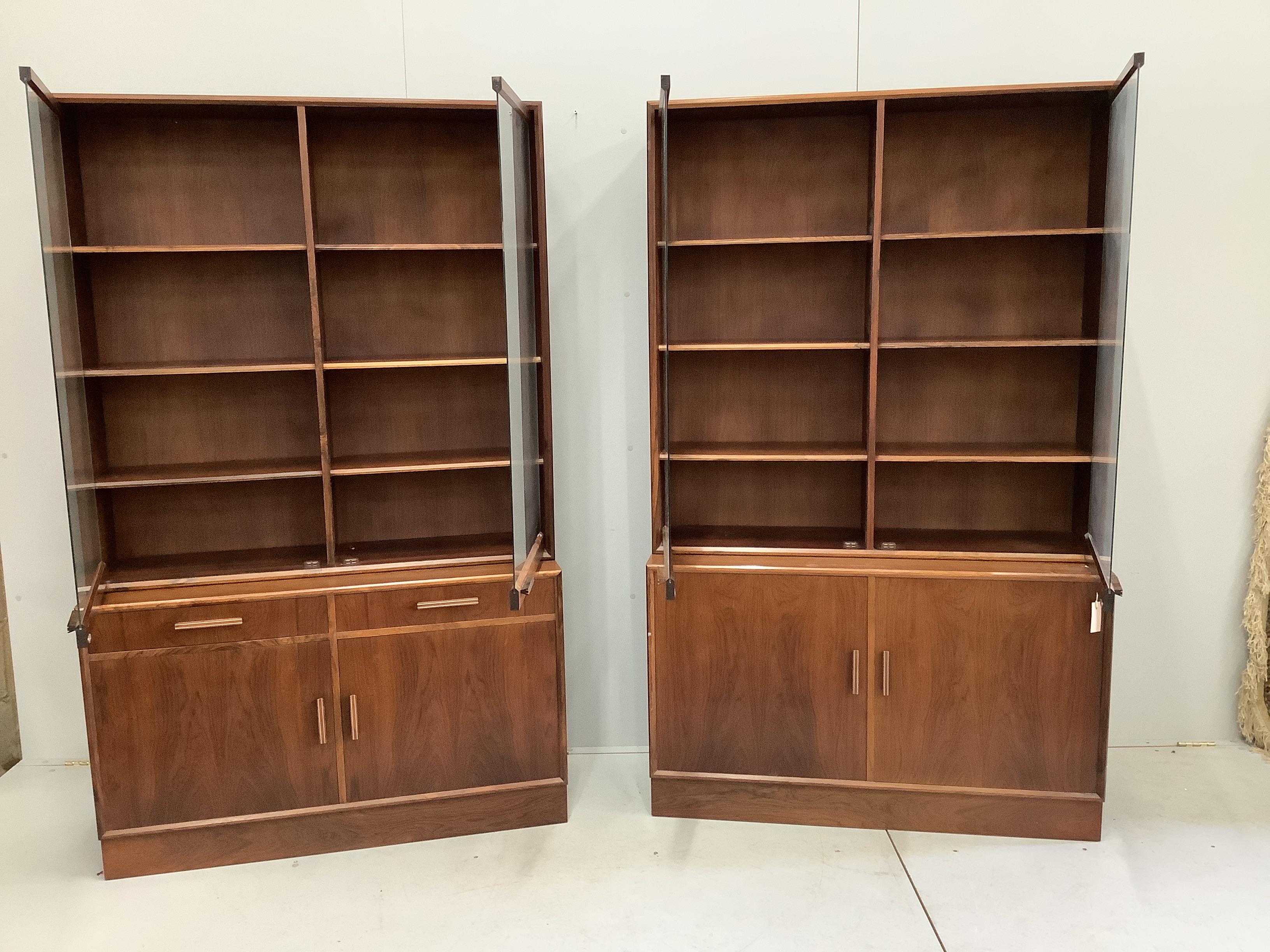 A pair of mid century Indian rosewood glazed cabinets with adjustable shelves, width 110cm, depth 38cm, height 180cm